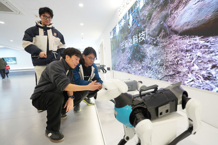 2025年2月28日,杭州云深处科技有限公司技术支持团队的工程师杨俊(右)在公司为客户介绍一款四足机器人。新华社记者 翁忻旸 摄